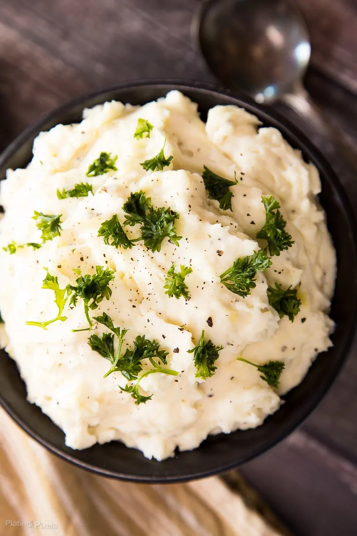 Creamy mashed potatoes garnished with fresh herbs for a comforting side dish.