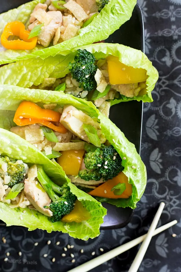 Chicken lettuce wraps with broccoli, bell peppers, and rice in lettuce cups.