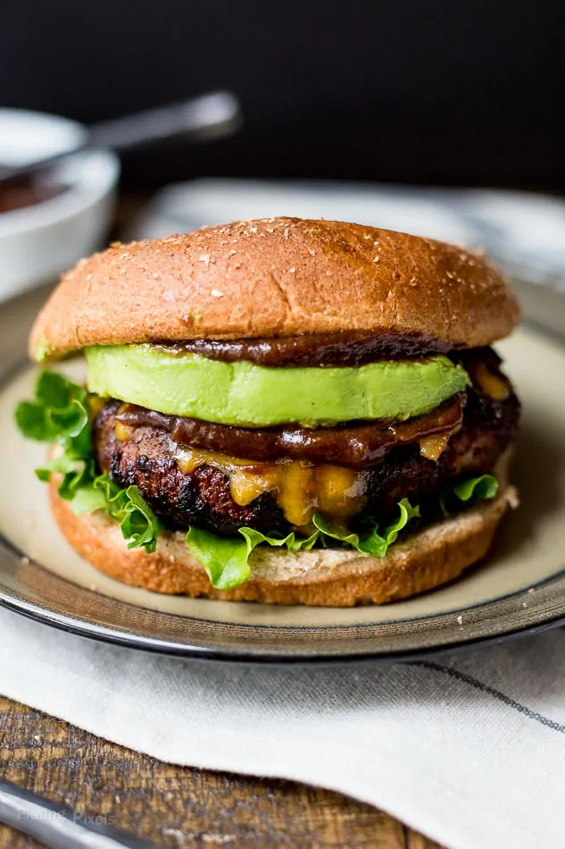 Honey BBQ bacon burger with fresh avocado and lettuce on a toasted bun.
