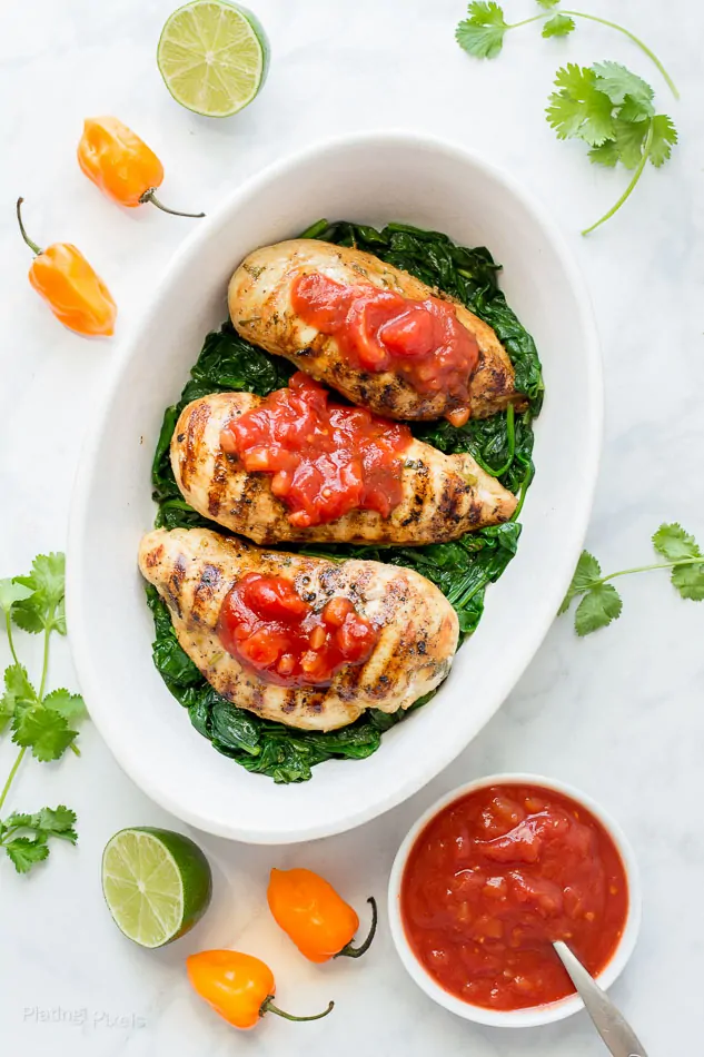 Lime marinated chicken topped with mango habanero salsa on a white platter.