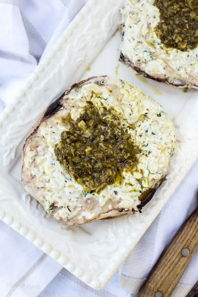 Ricotta stuffed Portobello mushrooms with herbs and pesto topping.
