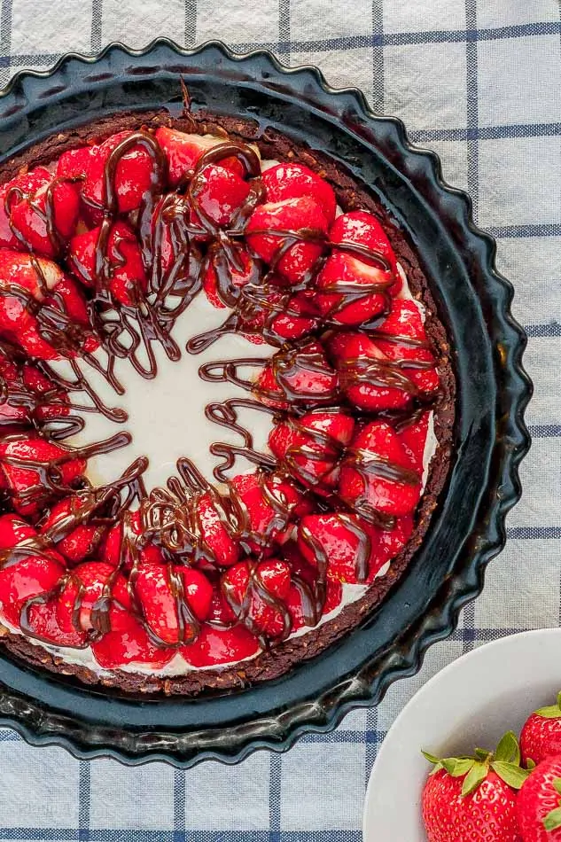 No bake cheesecake with strawberries and Nutella drizzle, perfect for summer desserts.