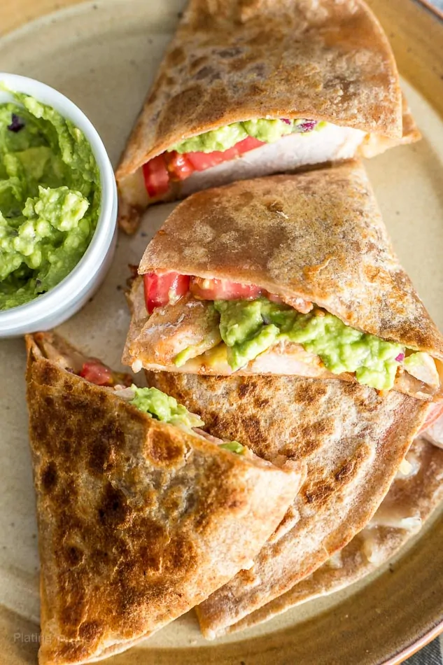 Pork quesadillas with fresh guacamole on a plate, perfect for a flavorful meal.