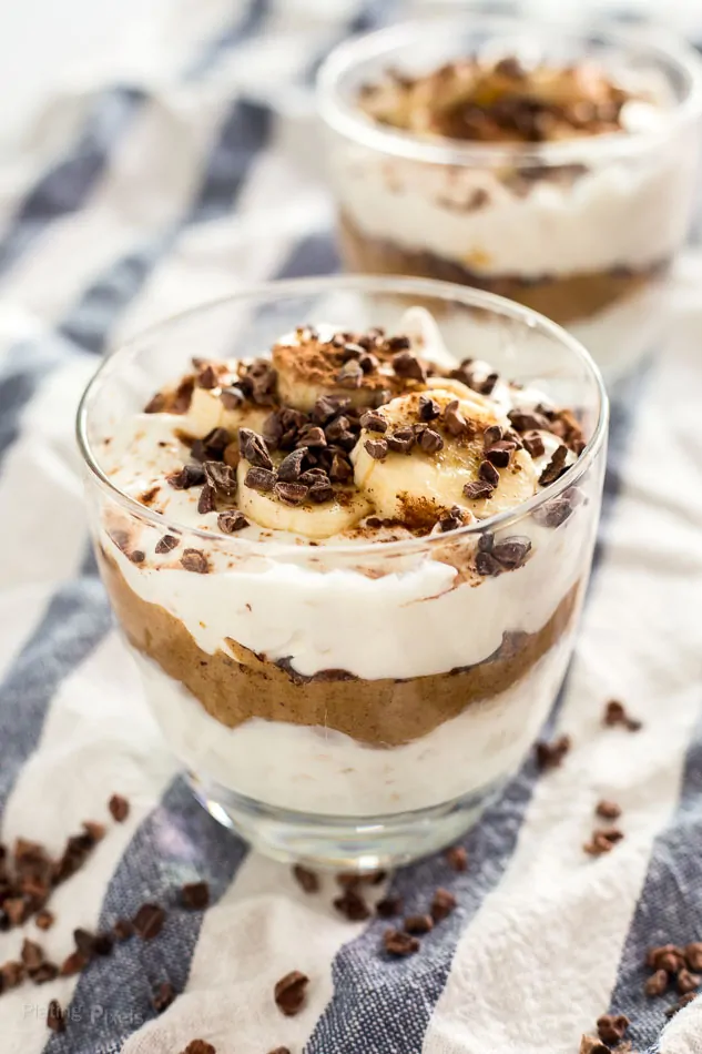 Creamy chocolate almond butter parfait with bananas and chocolate chips in a glass.