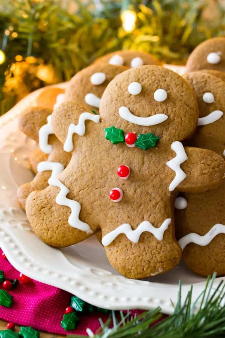 Festive gingerbread cookies decorated with white icing and holly accents for Christmas.