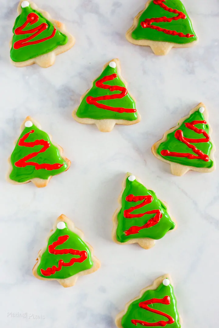 Christmas tree cookies decorated with green icing and red zigzag lines.