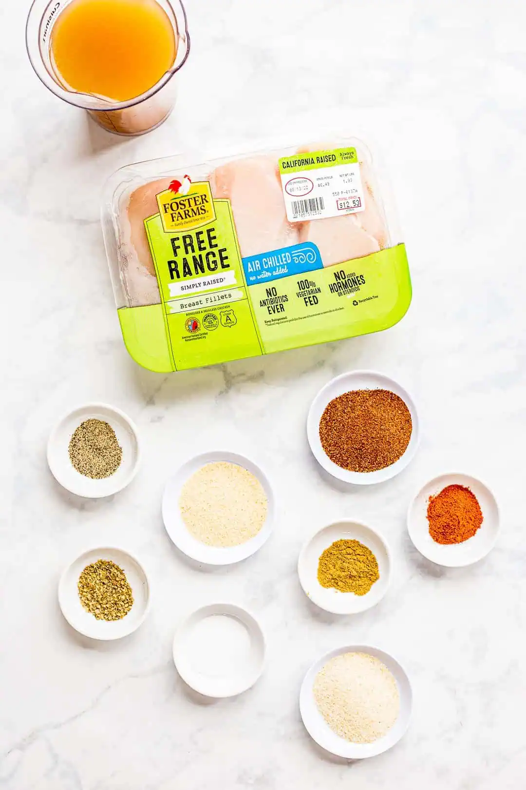Chicken and spices prepared on a counter for making slow cooker shredded chicken