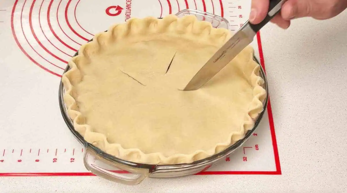 cuttings slits in top of apple pie crust Cuttings slits in top of an apple pie crust