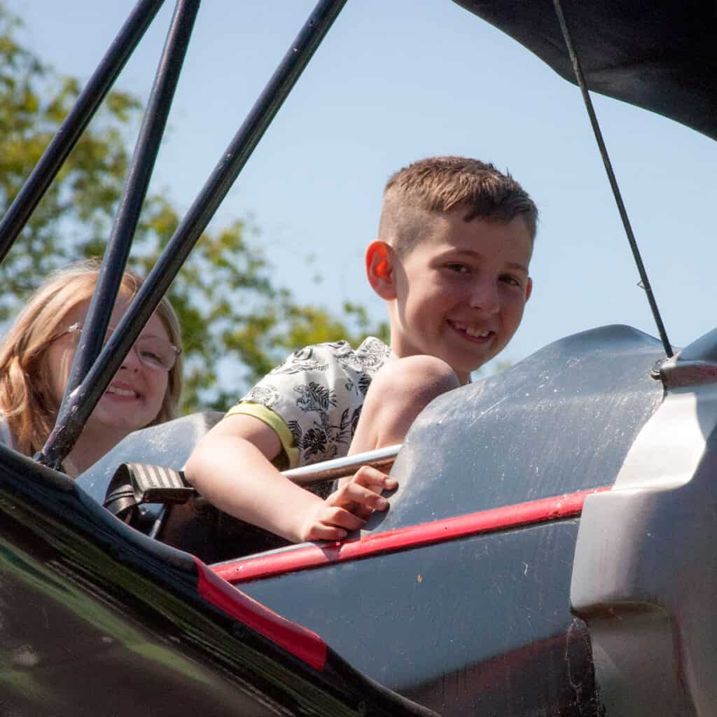 Young boy and young girl on aeroplane themed amusement park ride