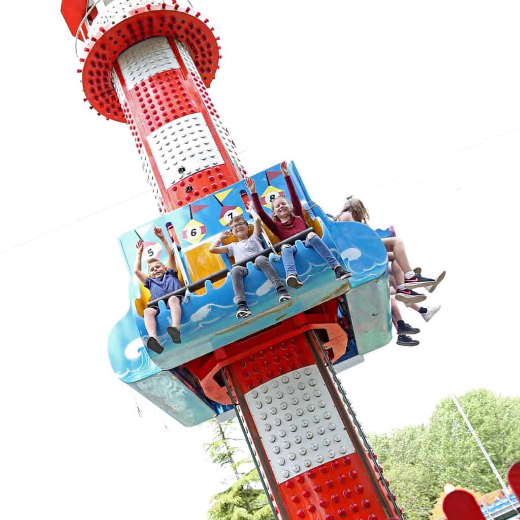 Group of children on a drop tower theme park ride