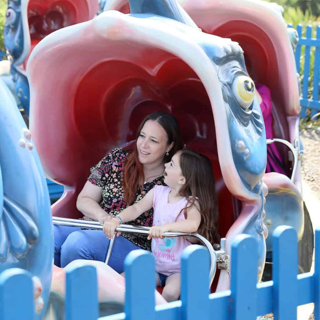 Woman and young girl on whale theme park ride