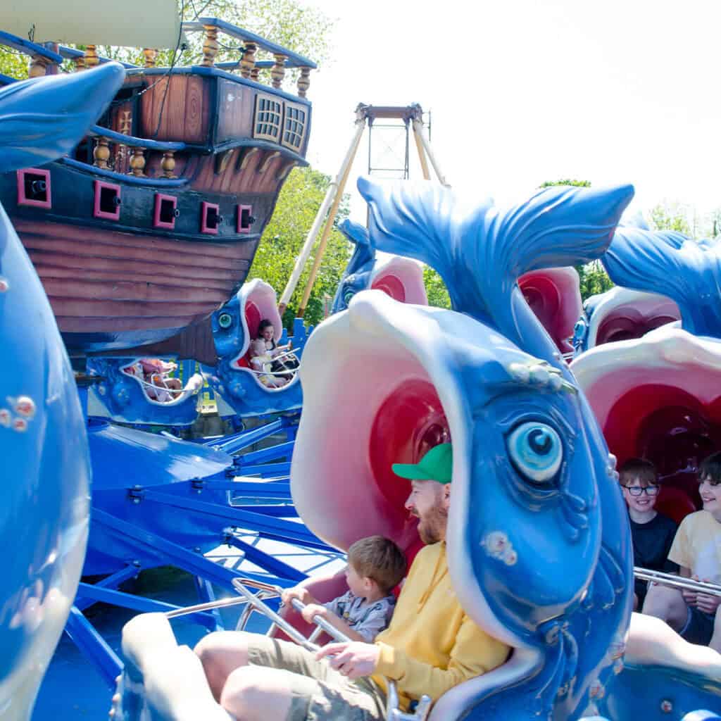 Man and young boy on whale theme park ride