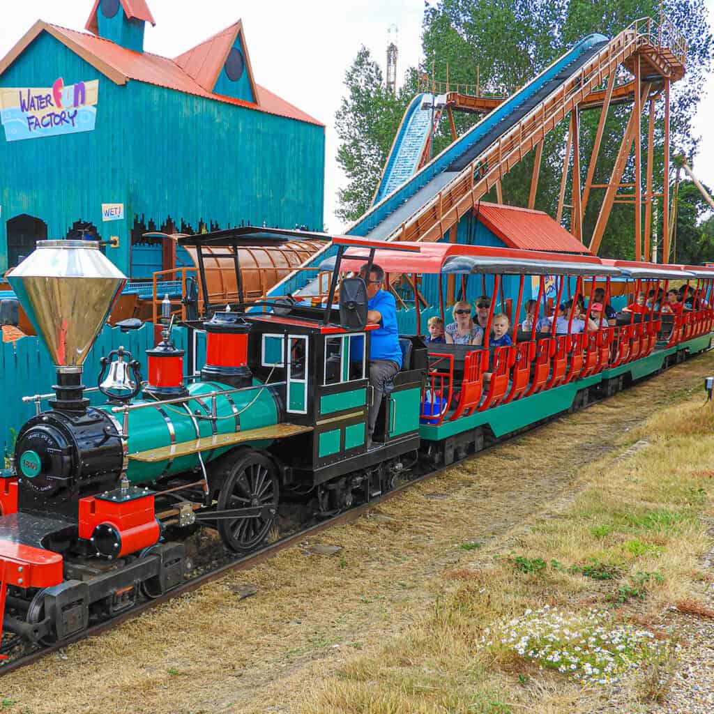 Green and red passenger train at a theme park