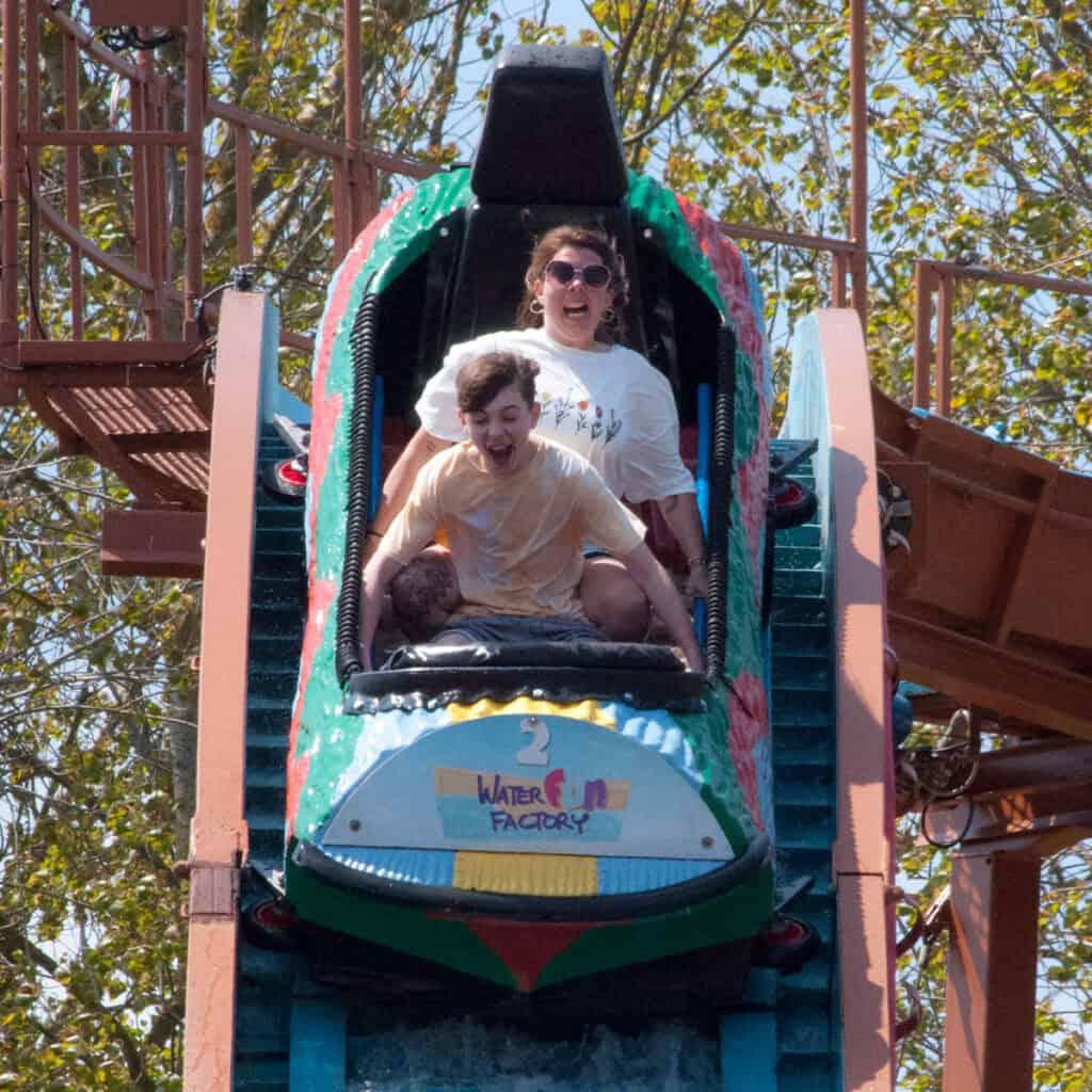 Woman and young boy descending on a log flume