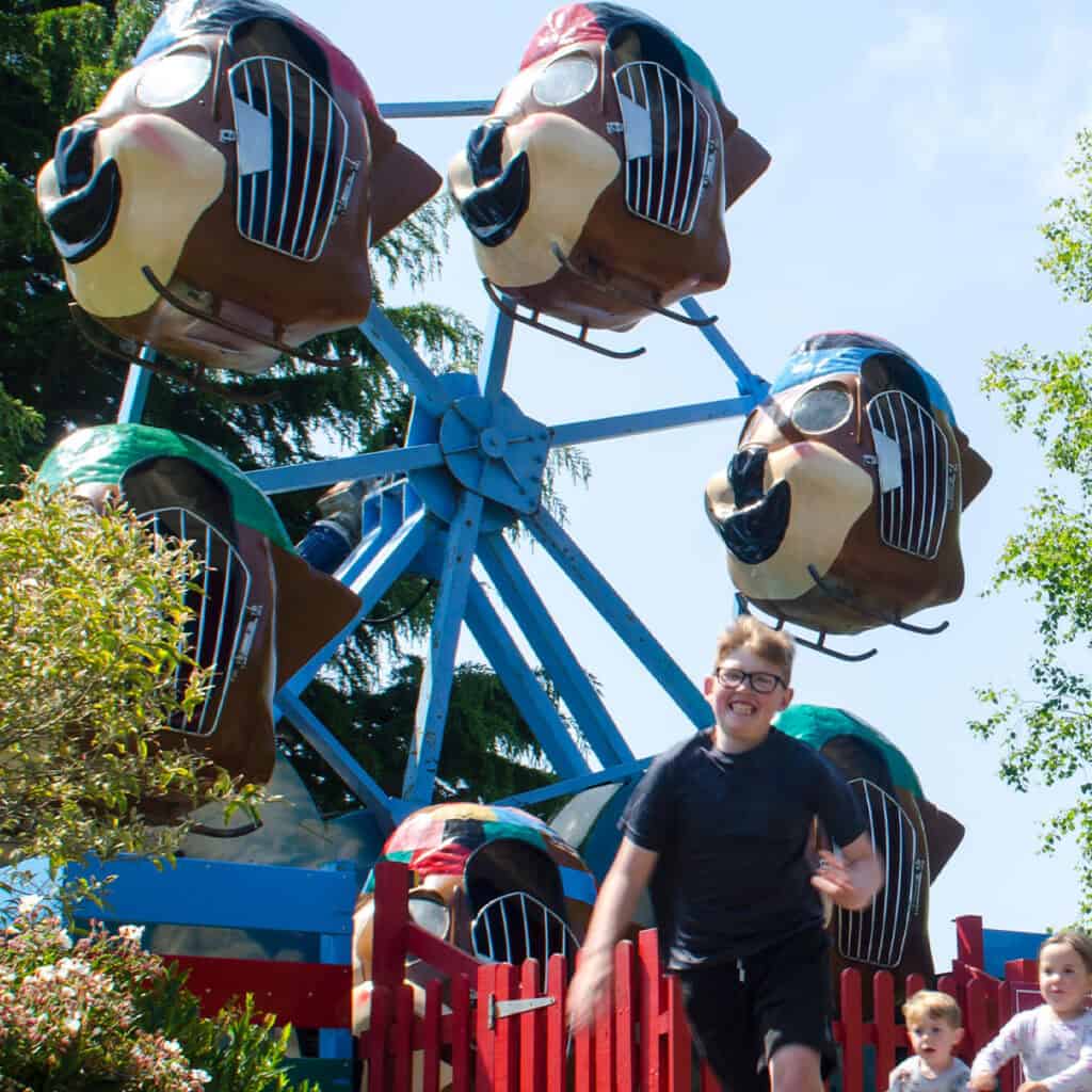 Children running past theme park ride