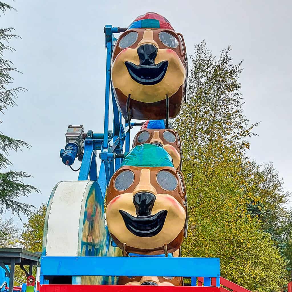 Side view of children's helicopter wheel theme park ride