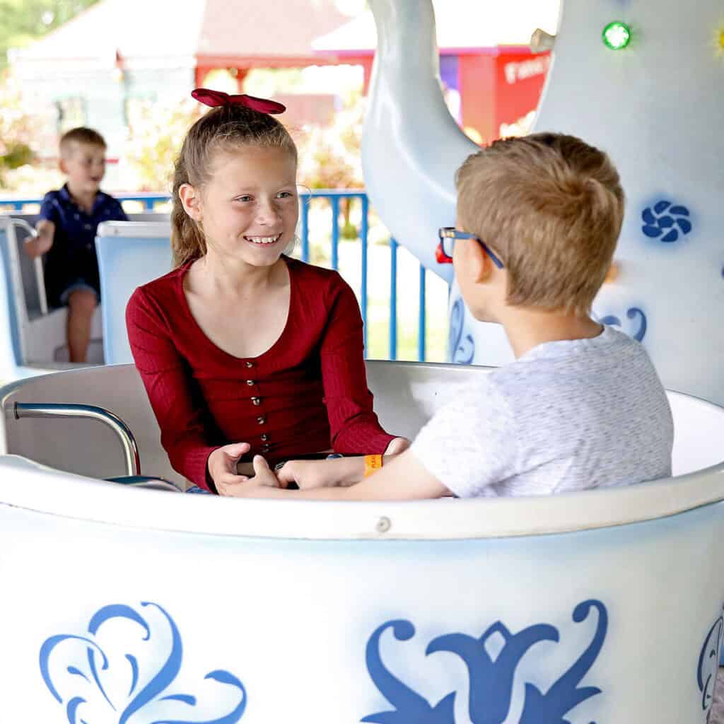 Young girl and young boy on a teacups ride