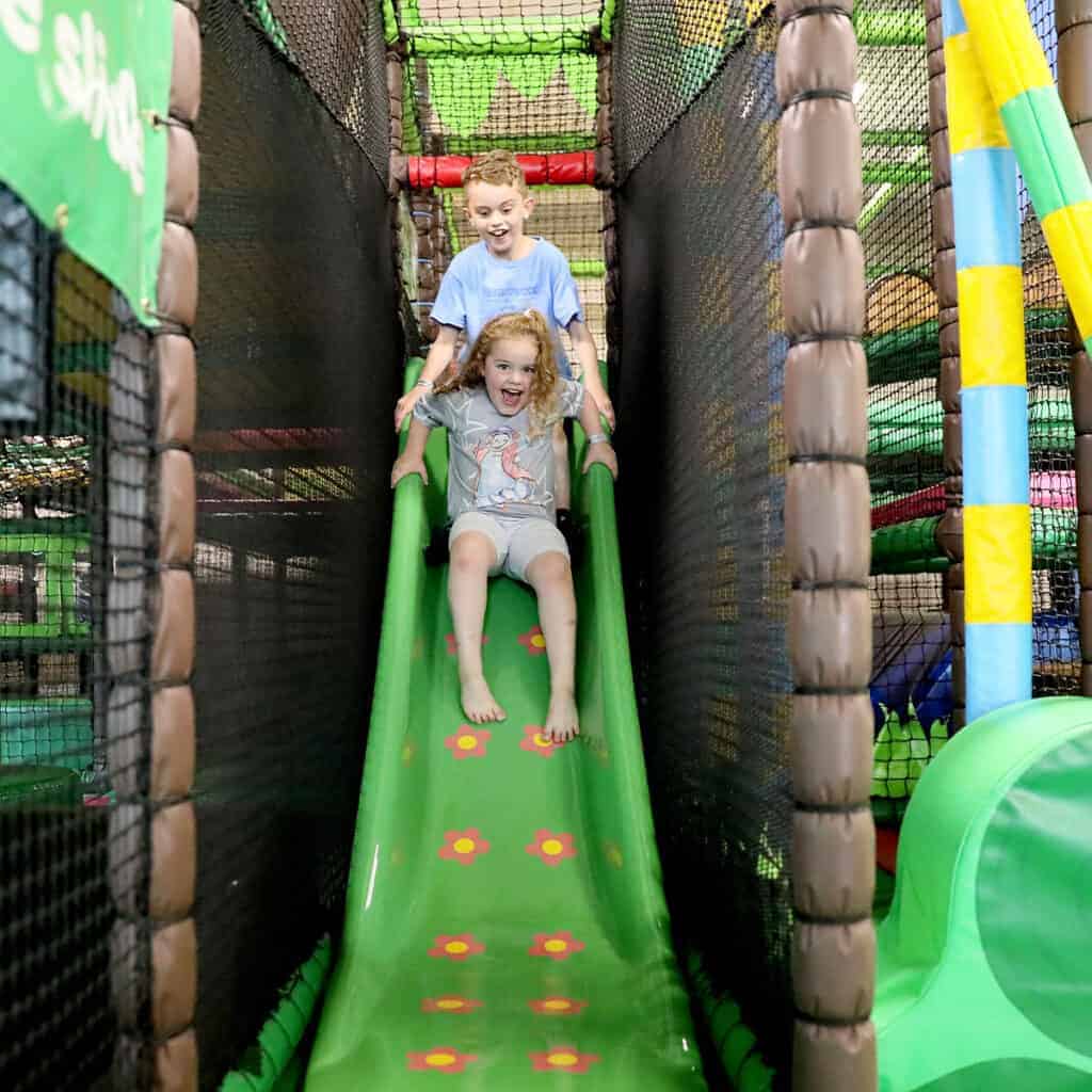 Young boy and young girl on a slide