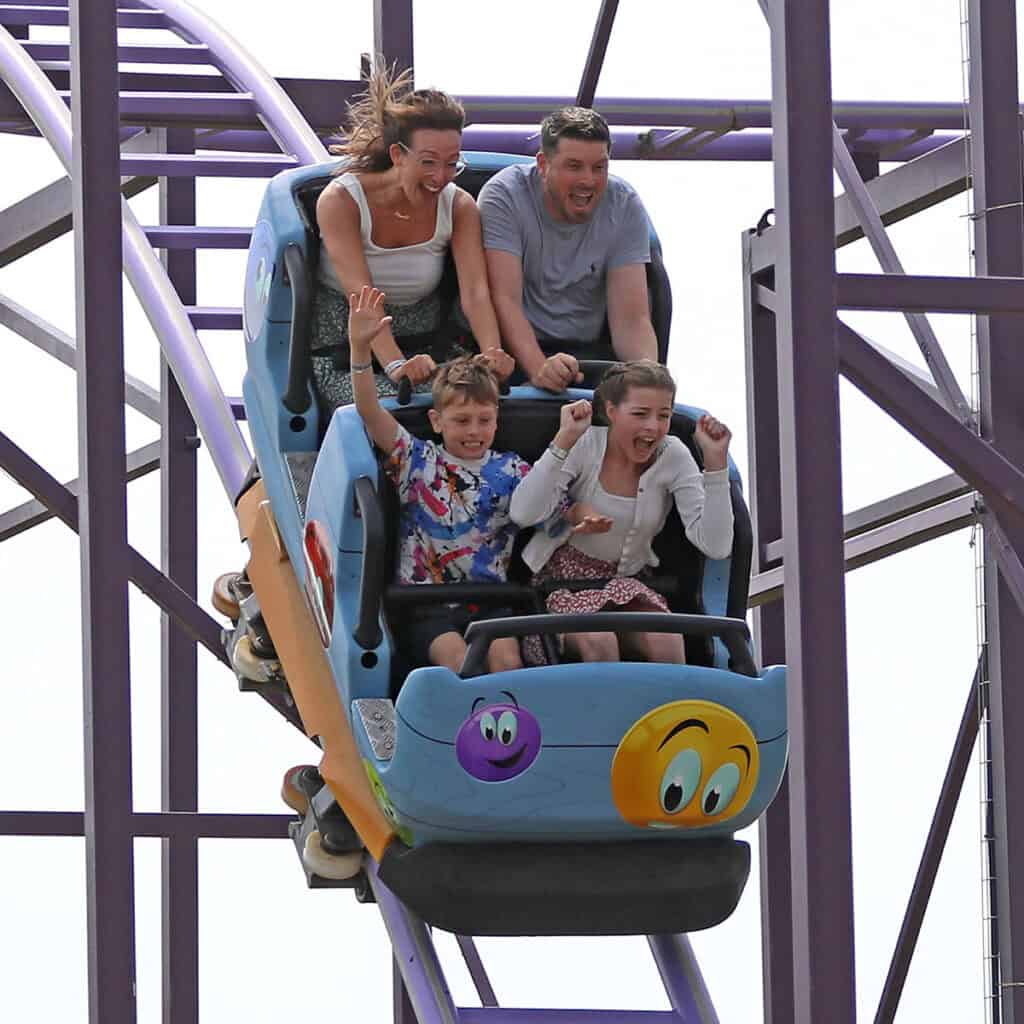 Family in a on a rollercoaster in a blue rollercoaster cart