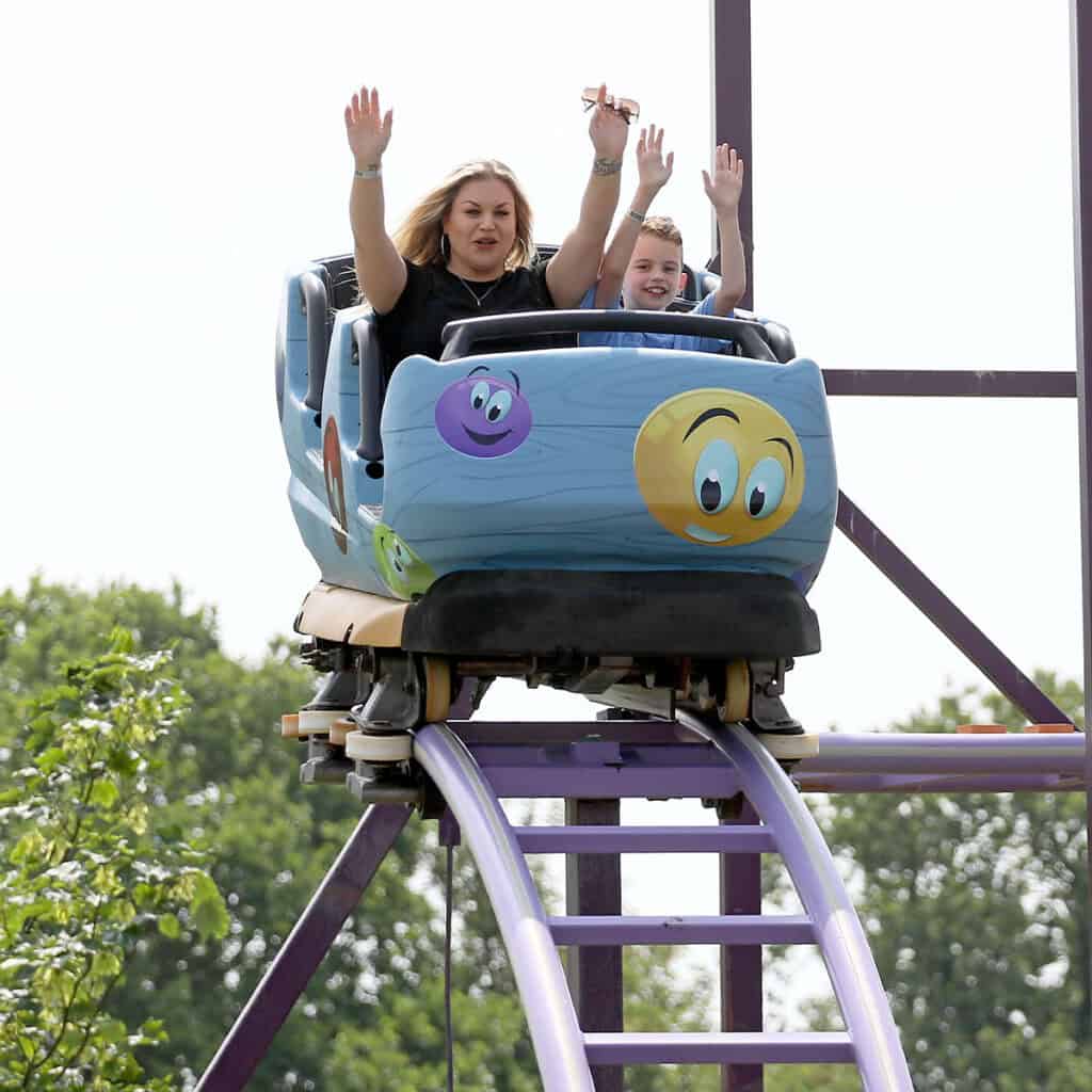 Lady and a young girl in a blue rollercoaster cart.