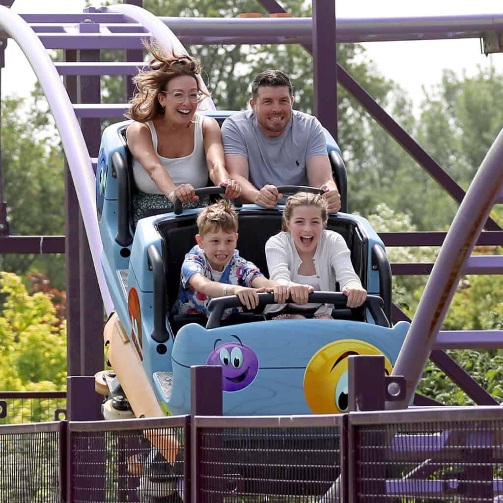 Family in a blue rollercoaster cart