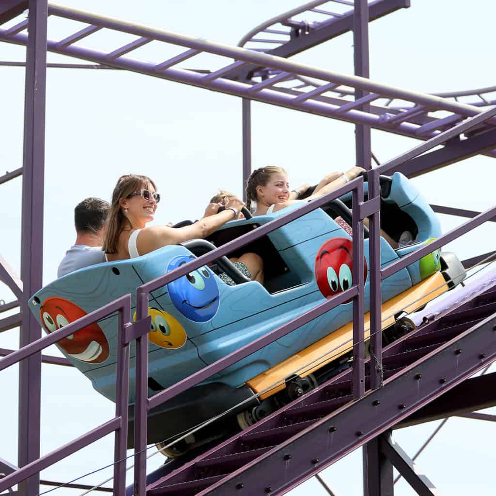Family in a blue rollercoaster cart