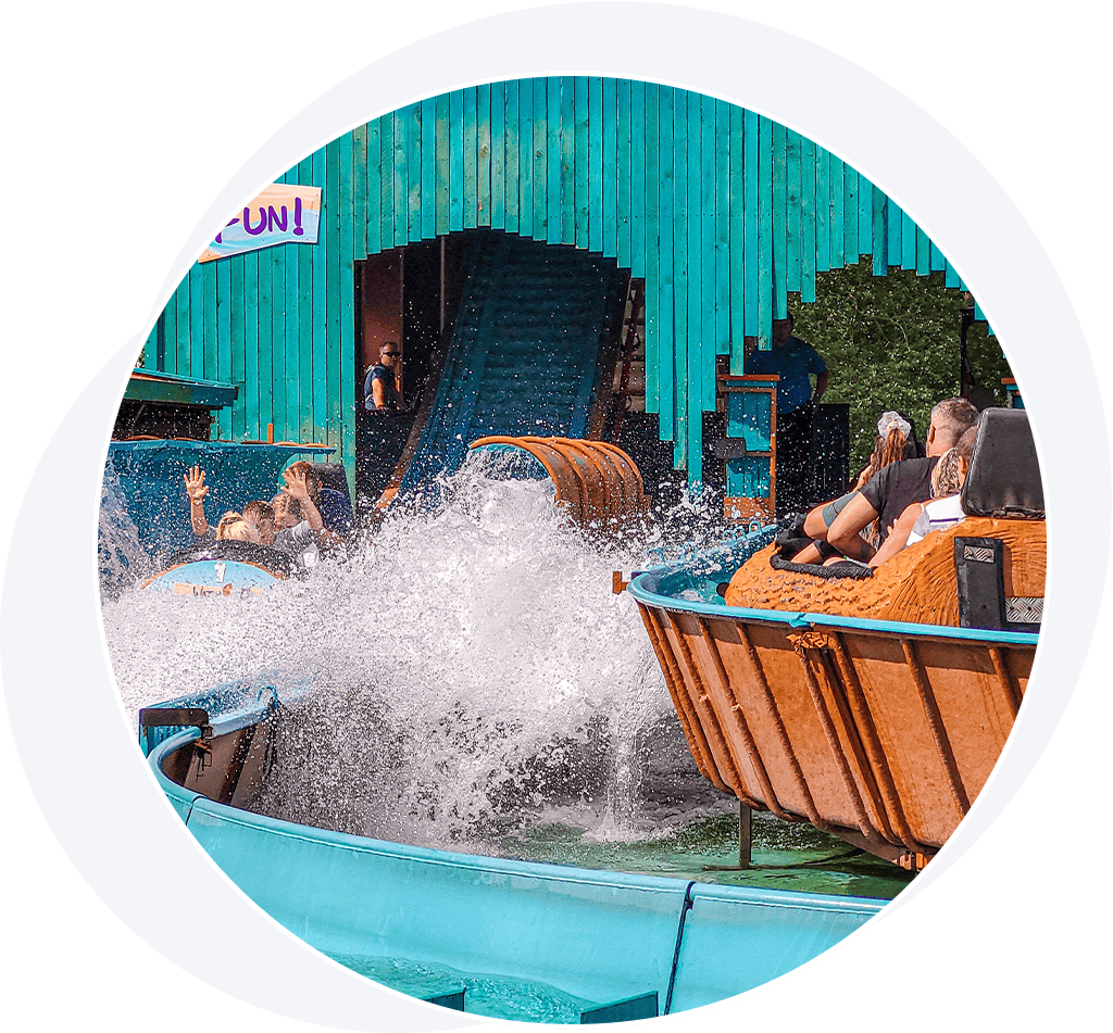 Flumes with people in splashing on a log flume water ride.