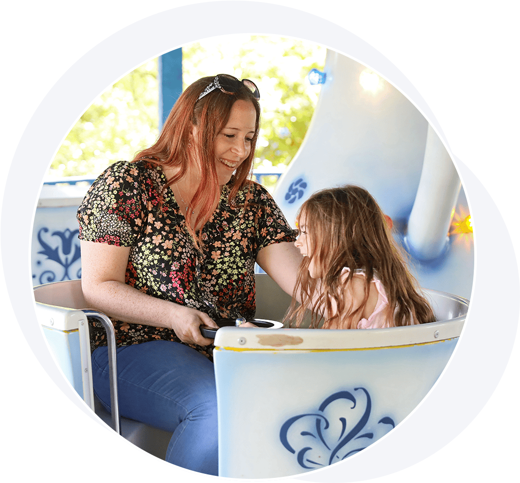 Woman and young girl on teacups ride