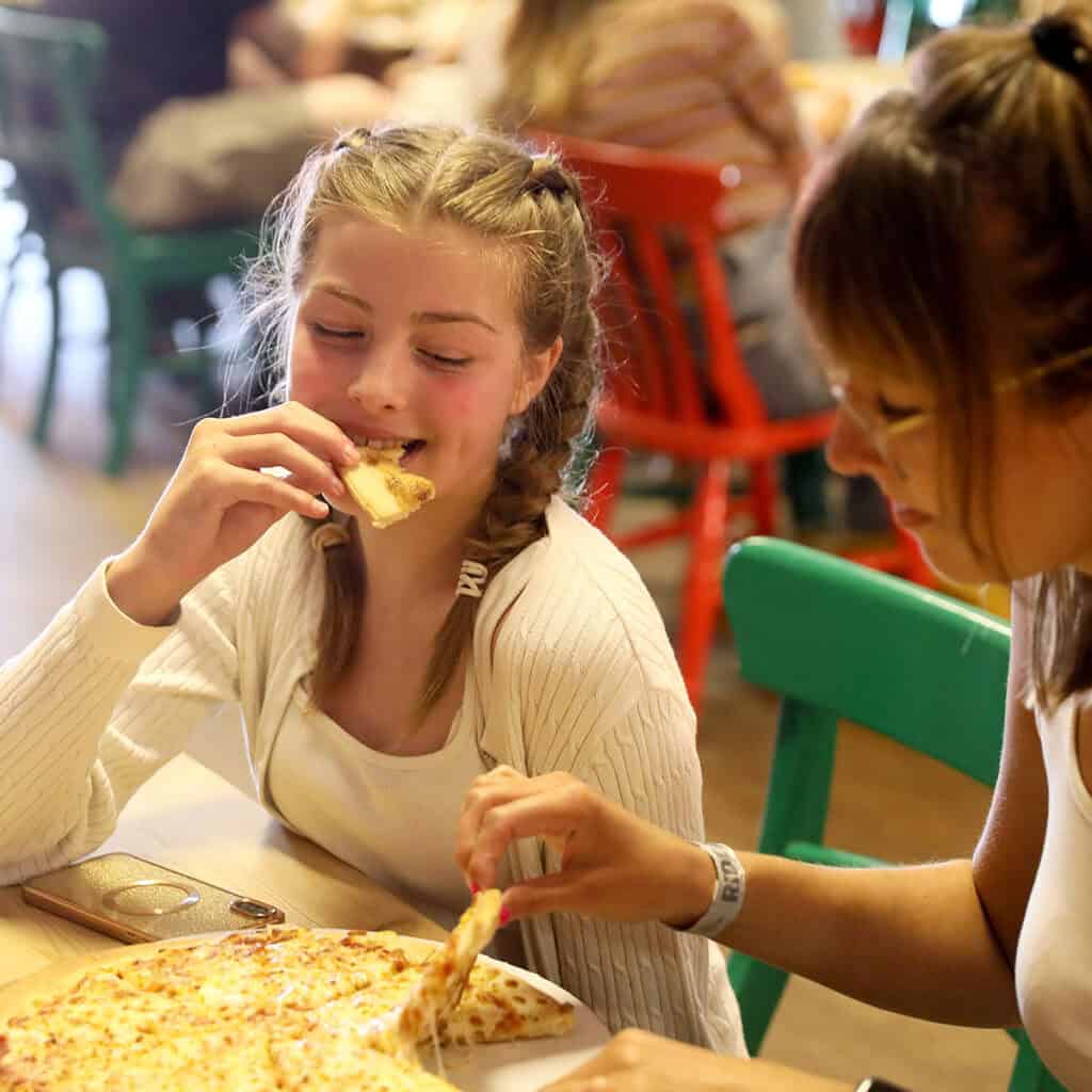 Woman and young girl enjoying pizza