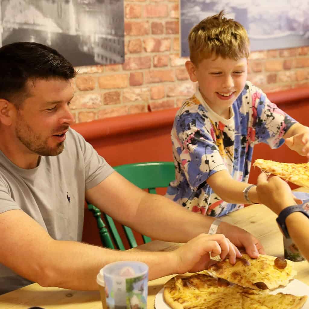 Man and a young boy enjoying pizza