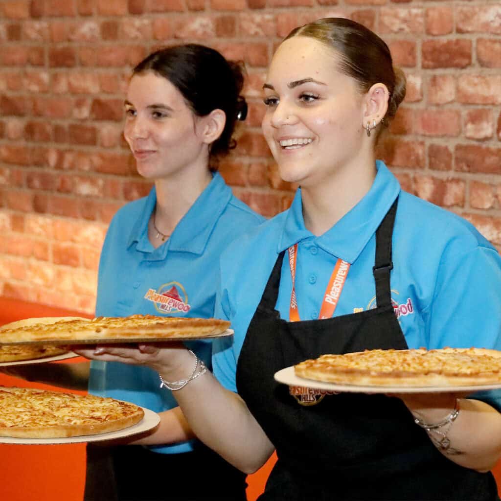 Two female servers with pizza