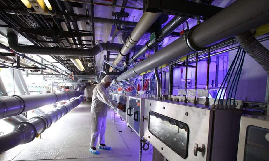 Technician in a tunnel servicing industrial pipes