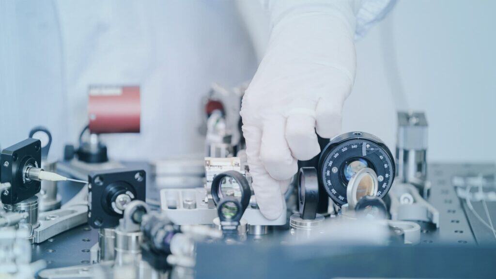 Engineer monitoring air contamination levels using a portable Lasair Pro particle counter in a cleanroom.