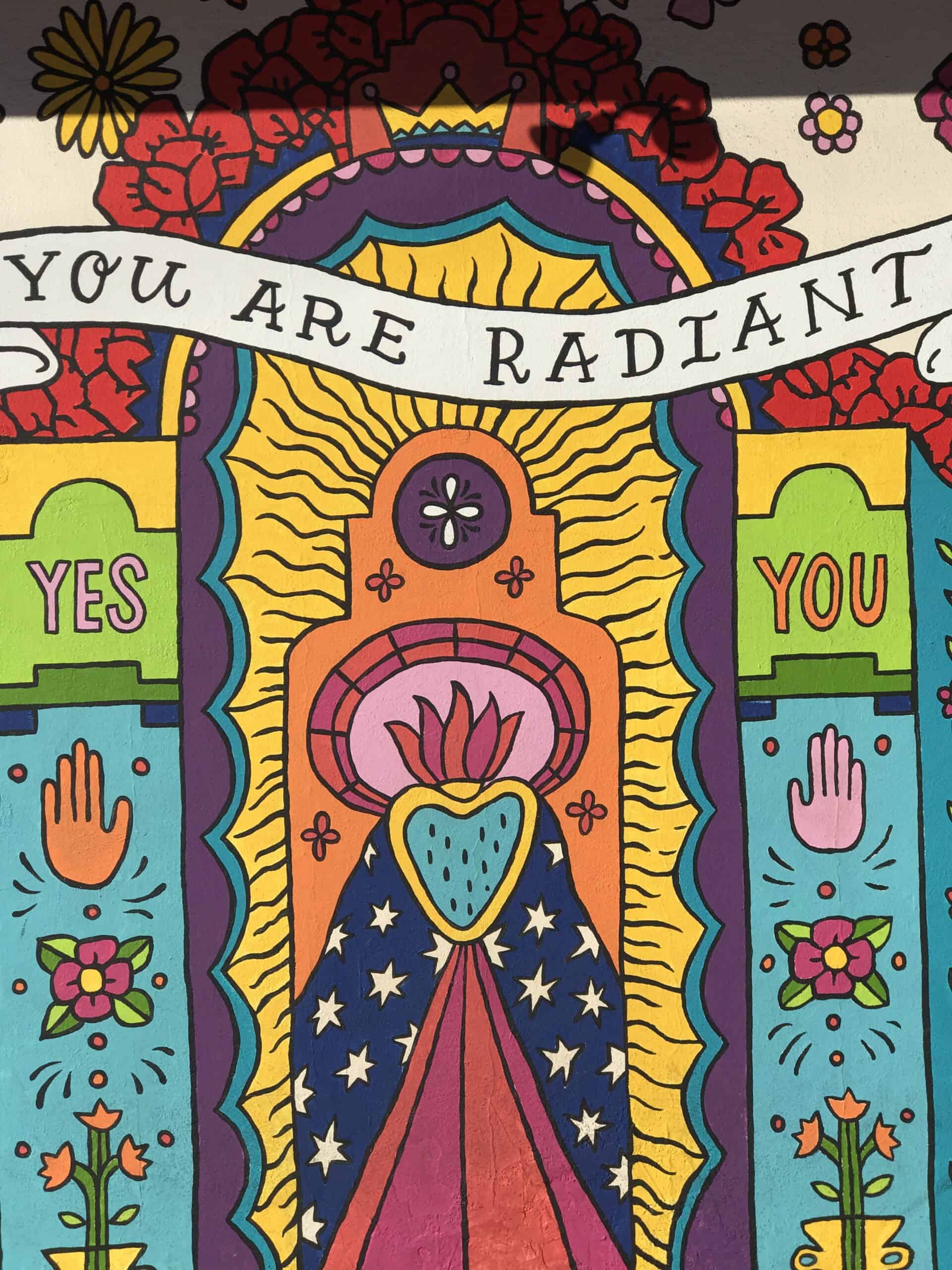 Colorful mural art at Point North Park in San Diego, California, featuring vibrant designs, uplifting messages like "You Are Radiant," and symbolic imagery promoting positivity and community engagement.