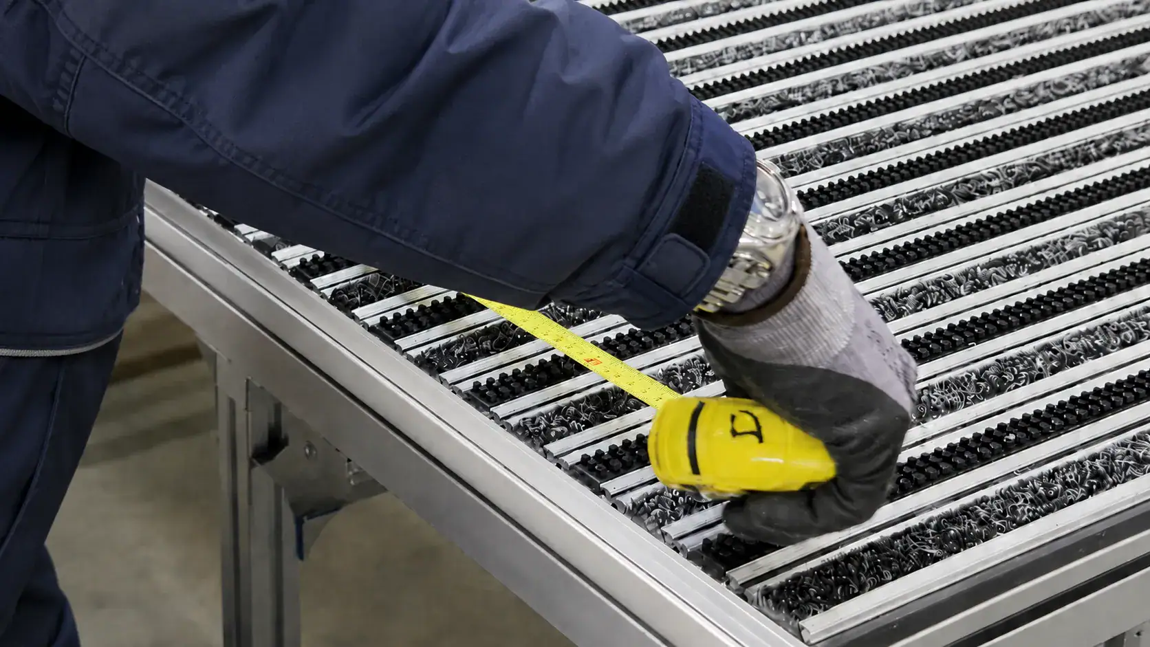 Pracownik produkcji mierzy wycieraczkę aluminiową Polentex