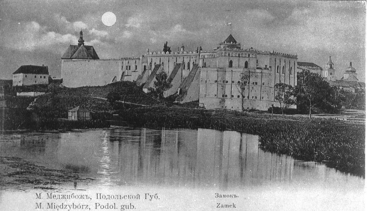 Історична фотографія Меджибізької фортеці на річці з підписом українською та англійською.