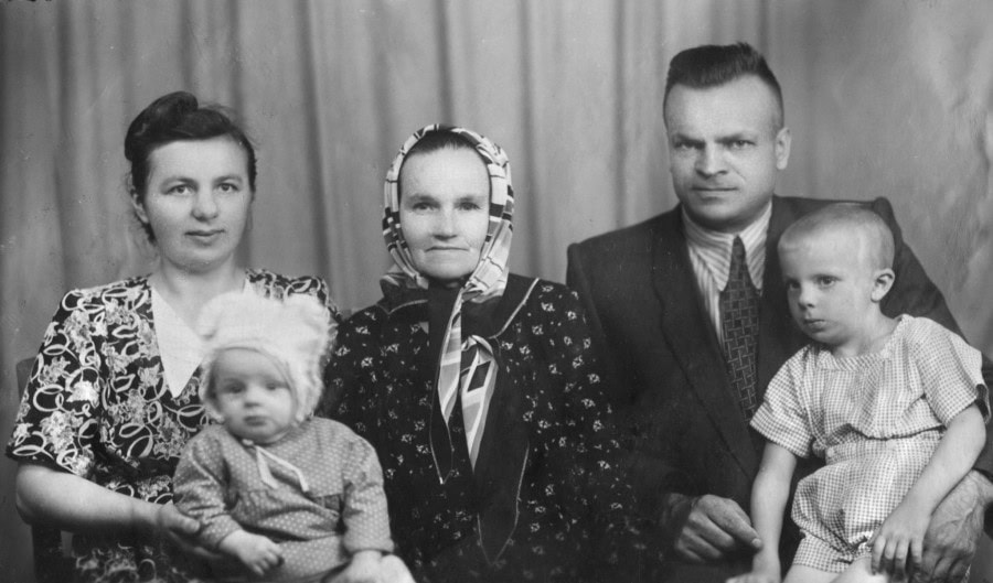 Чотири дорослі та двоє дітей у старовинній фотографії.