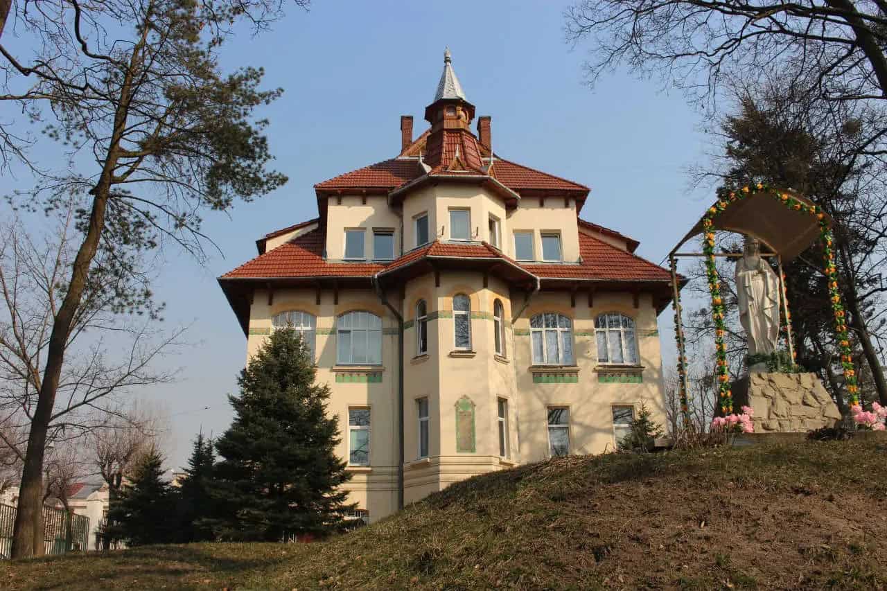 Модерновий український особняк з червоною черепицею та баштою.