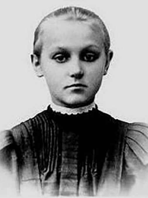 Чорнобіла фотографія жінки з серйозним виразом обличчя.