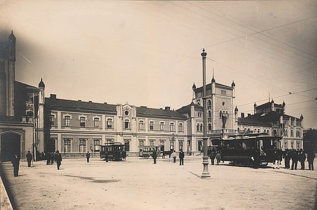 Історична фотографія українського архітектурного модерну з трамваями та людьми.