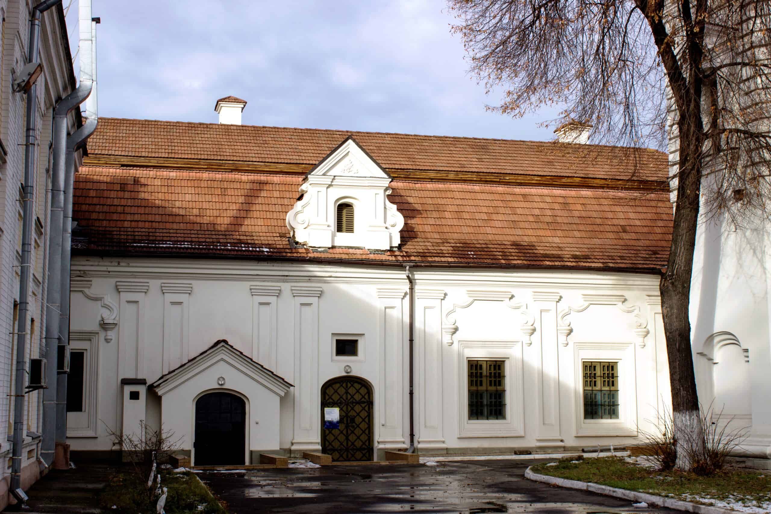 Історична будівля з білою фасадою та червоною черепицею на даху.