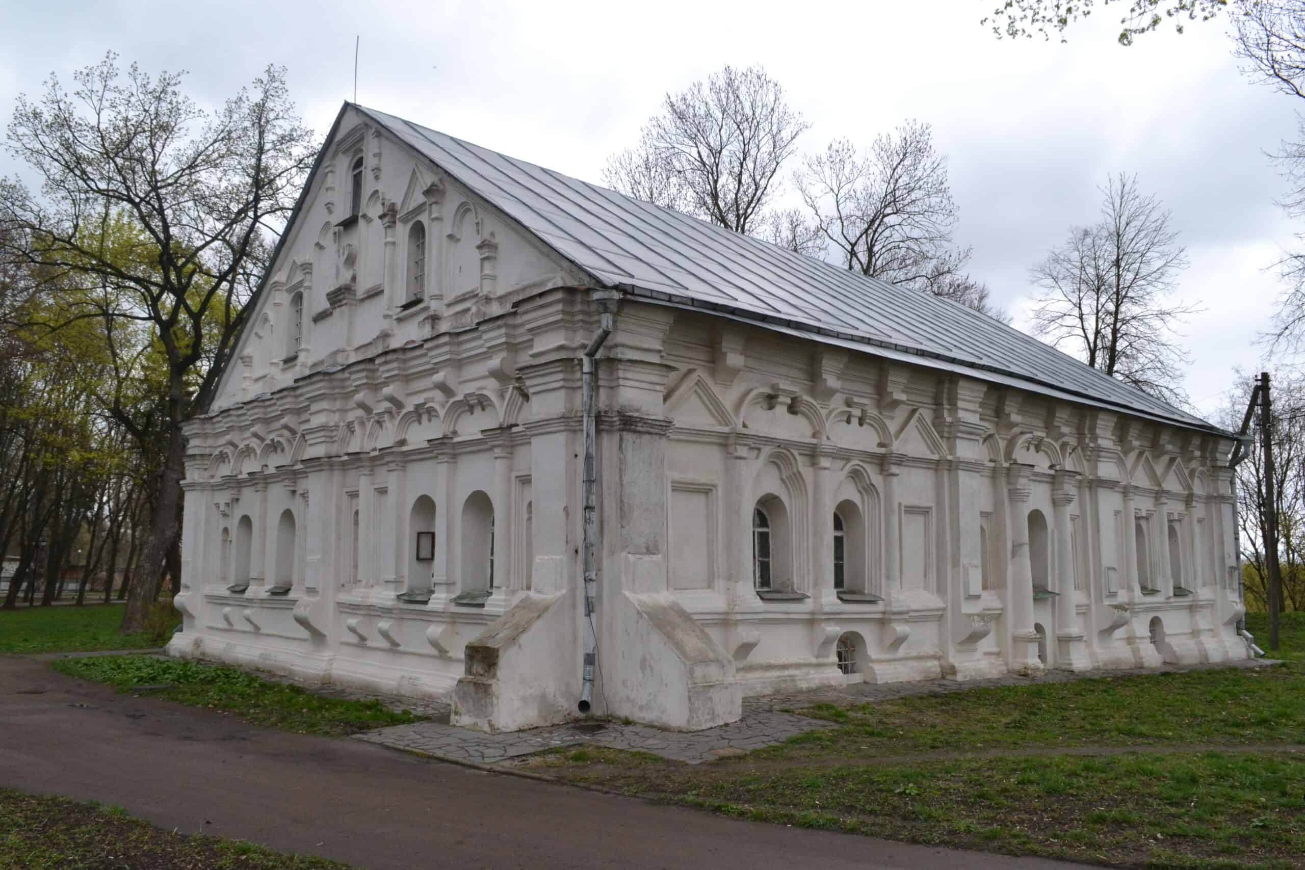 Історична церква у стилі козацького бароко з білого каменю, оточена деревами.
