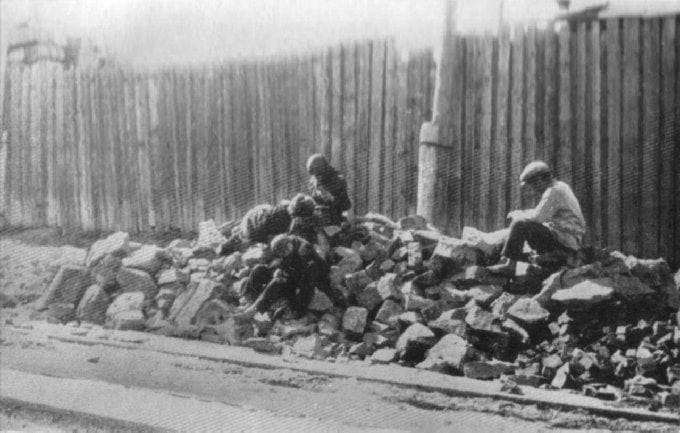 Діти сидять на руїнах, що залишилися після голоду 1932–1933 років в Україні.