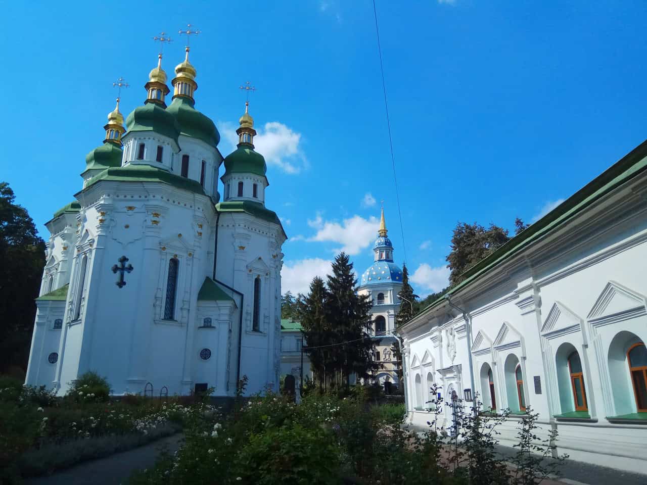 Козацька церква з золотими куполами на фоні блакитного неба.