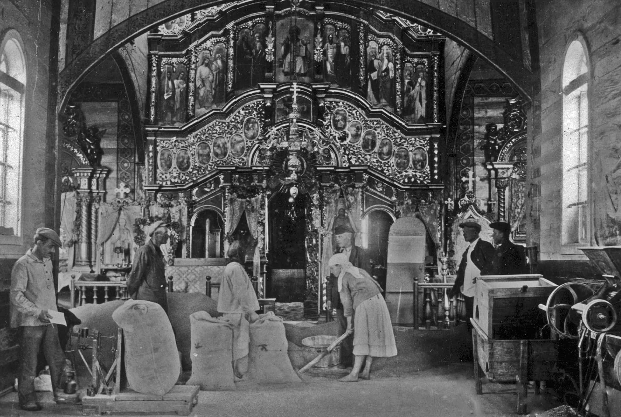 Робітники в церкві з великим іконостасом, історична фотографія.