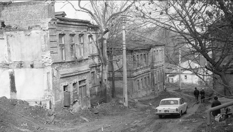 Зруйновані будівлі на вулиці, чорнобілий знімок, історична фотографія.