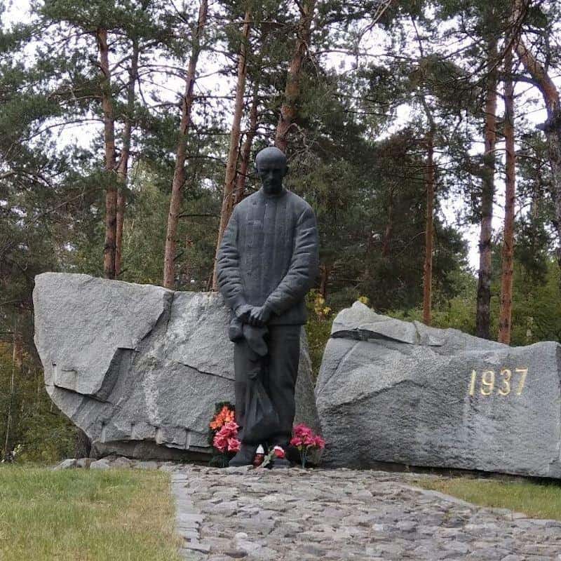 Пам'ятник воїну з квітами біля кам'яної стели 1937 року.