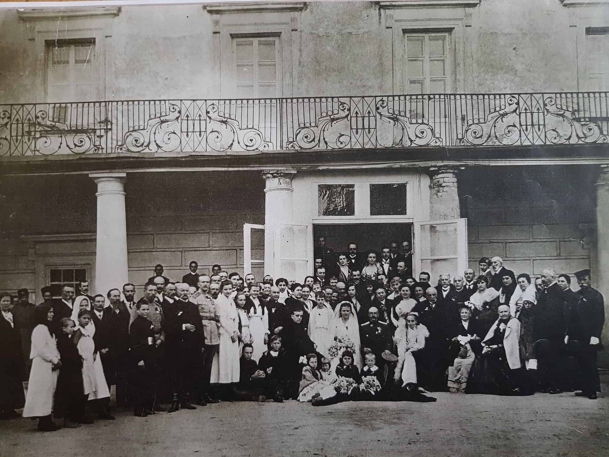 Групова фотографія людей на подвір'ї старовинної будівлі, історична фотографія.