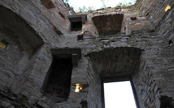 Зруйновані стіни Кудринецького замку з арками та вікнами.