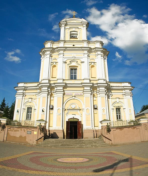 Барокова церква у Луцьку з яскравим небом і хмарами на фоні.